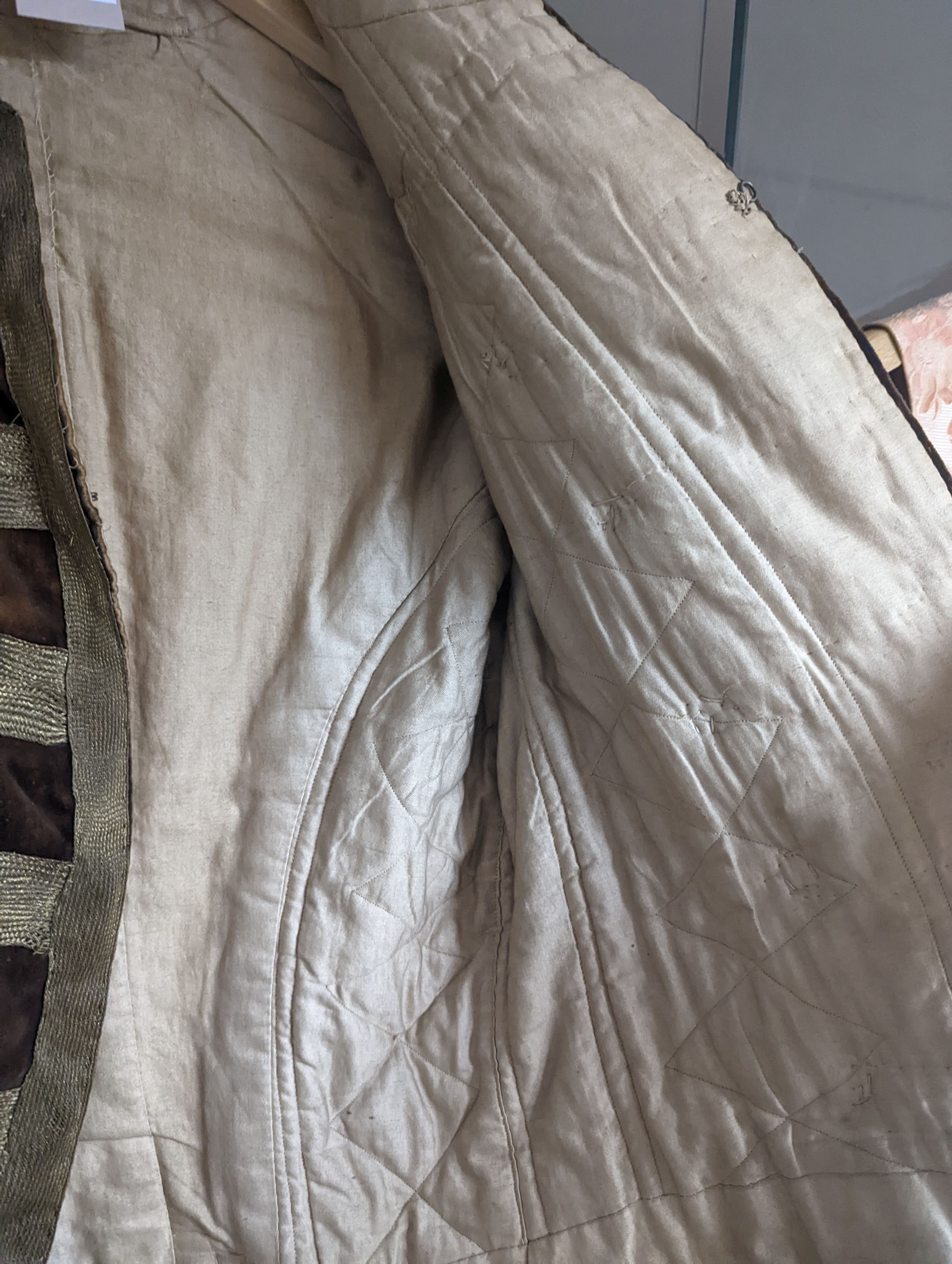 A Georgian gents cream damask waistcoat, a similar waistcoat with beading applied later and a velvet and gold braided tailcoat